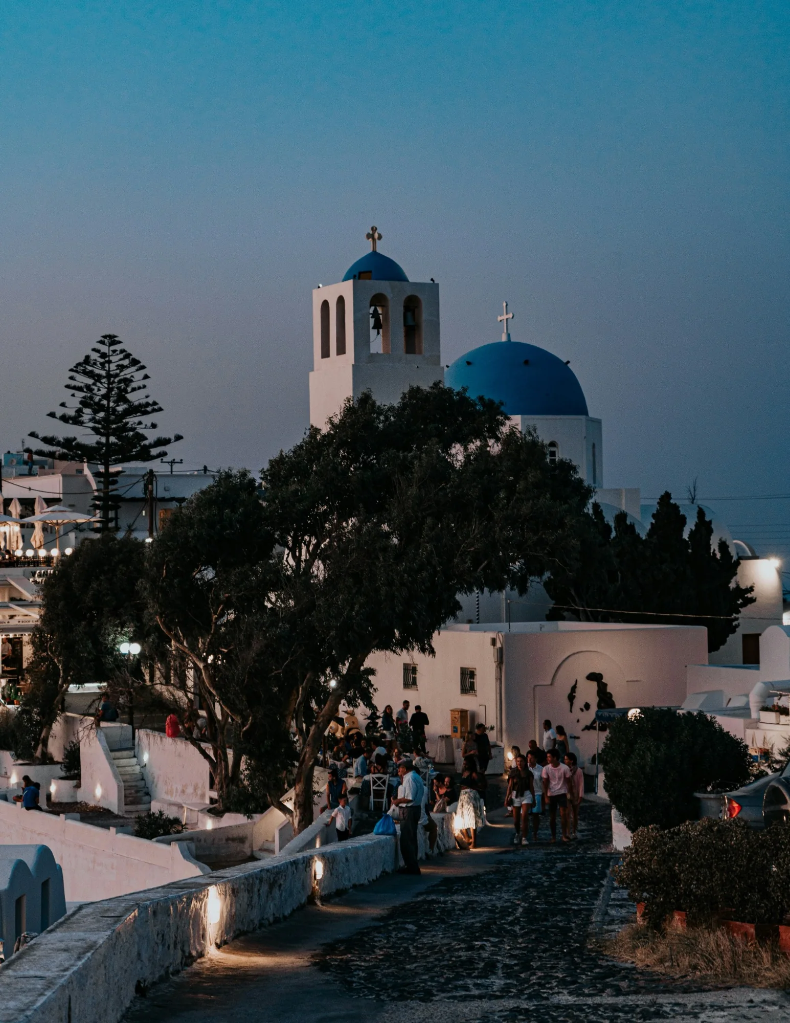Greek island village and blue-domed church at dusk